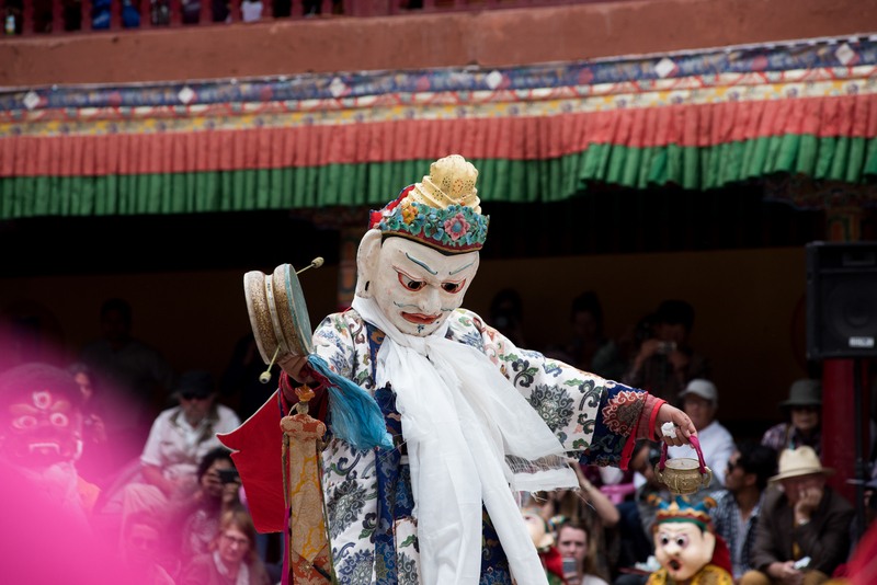 a man wearing a mask is performing a traditional dance