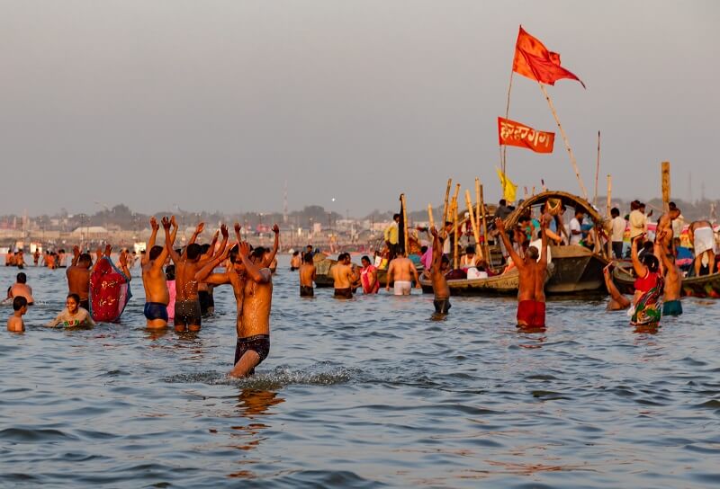 people taking holy dip at sangam
